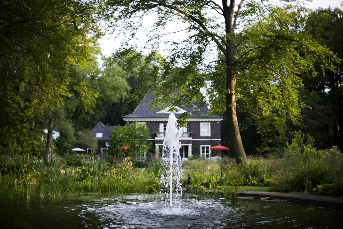Villengarten mit Springbrunnen und begleitender Staudenpflanzung.